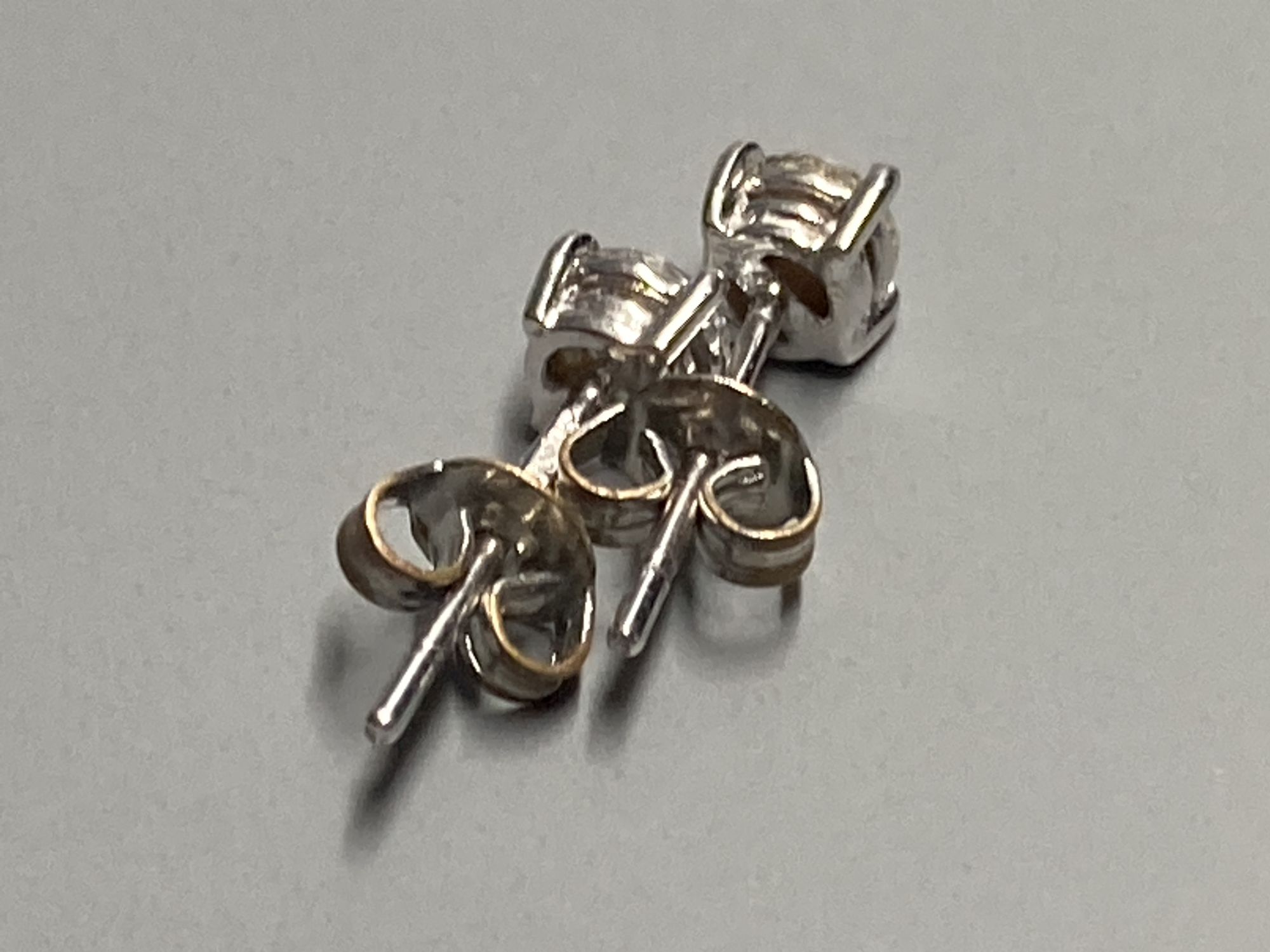 A modern pair of 18ct white gold and solitaire diamond set ear studs, gross 1 gram.